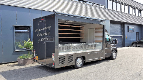 Zijaanzicht van een verkoopwagen voor kaas met geopende luifel