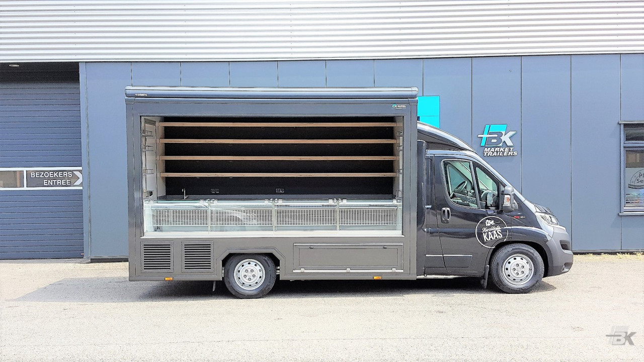 Zijaanzicht van een verkoopwagen voor kaas met geopende luifel