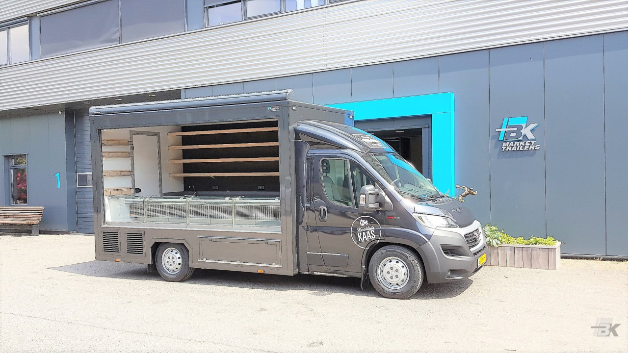 Zijaanzicht van een verkoopwagen voor kaas met geopende luifel