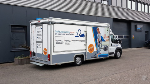 Zijaanzicht van een verkoopwagen voor stofzuigerzakken met gesloten luifel