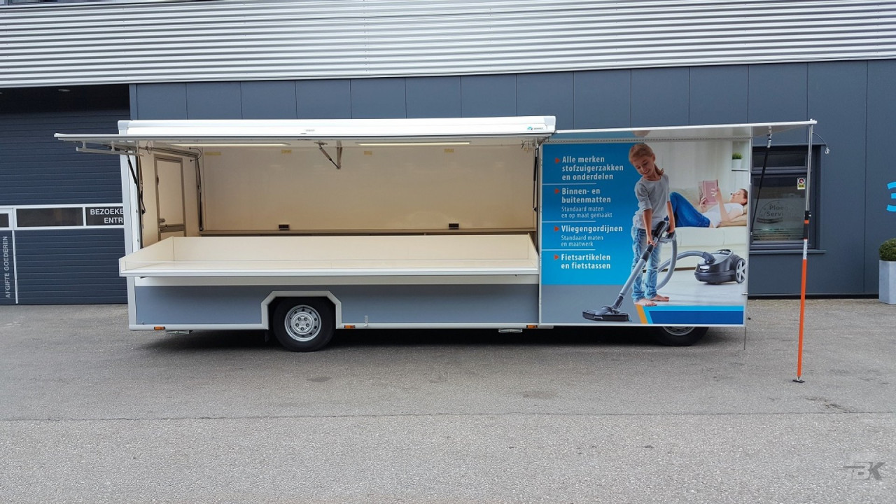 Zijaanzicht van een verkoopwagen voor stofzuigerzakken met geopende luifel