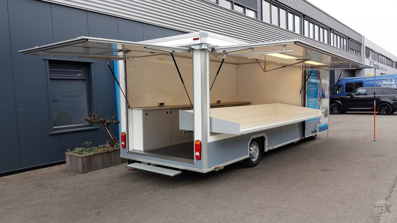 Zijaanzicht van een verkoopwagen voor stofzuigerzakken met geopende luifel