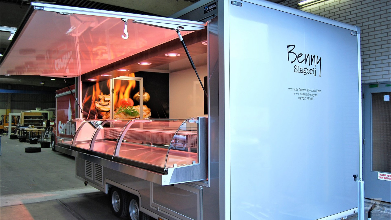 Zijaanzicht van een aanhangwagen voor vlees met geopende luifel
