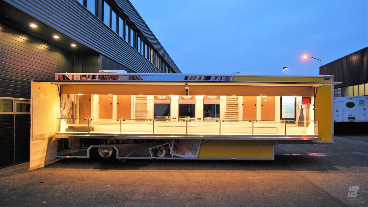Zijaanzicht van een verkoopwagen oplegger voor snoep met geopende luifel