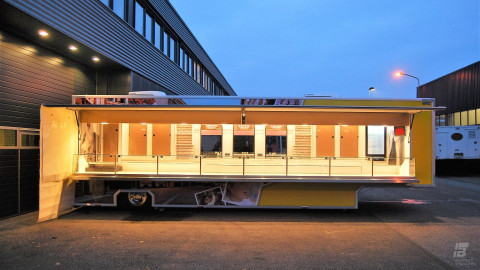 Zijaanzicht van een verkoopwagen oplegger voor snoep met geopende luifel