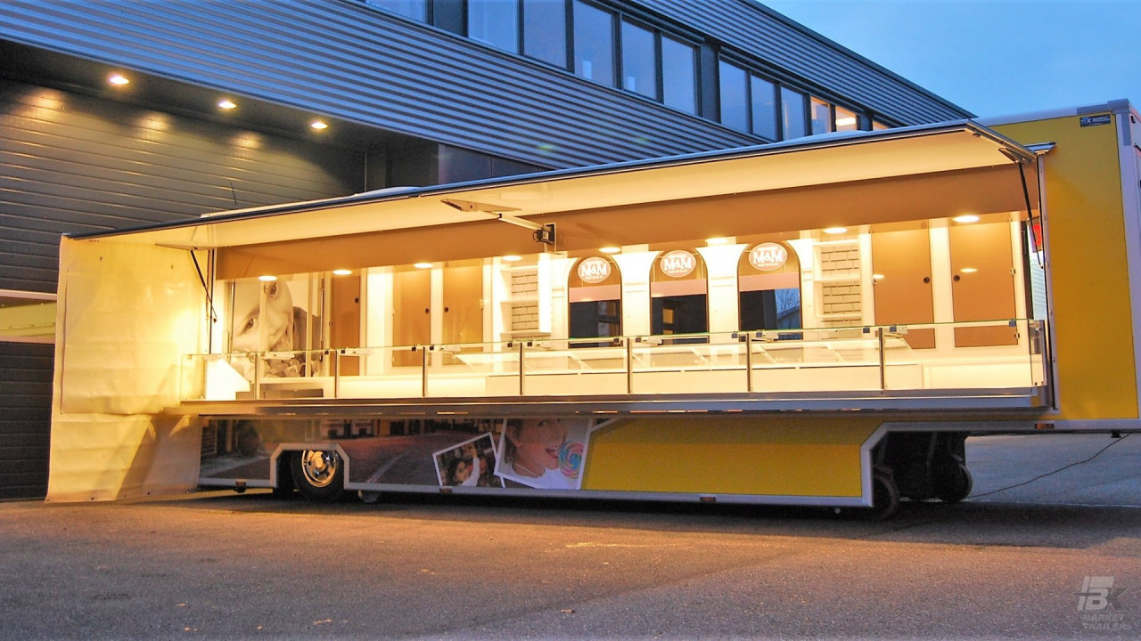 Zijaanzicht van een verkoopwagen oplegger voor snoep met geopende luifel
