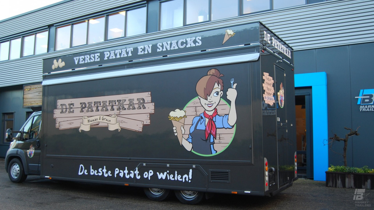 Zijaanzicht van een verkoopwagen voor patat met gesloten luifel