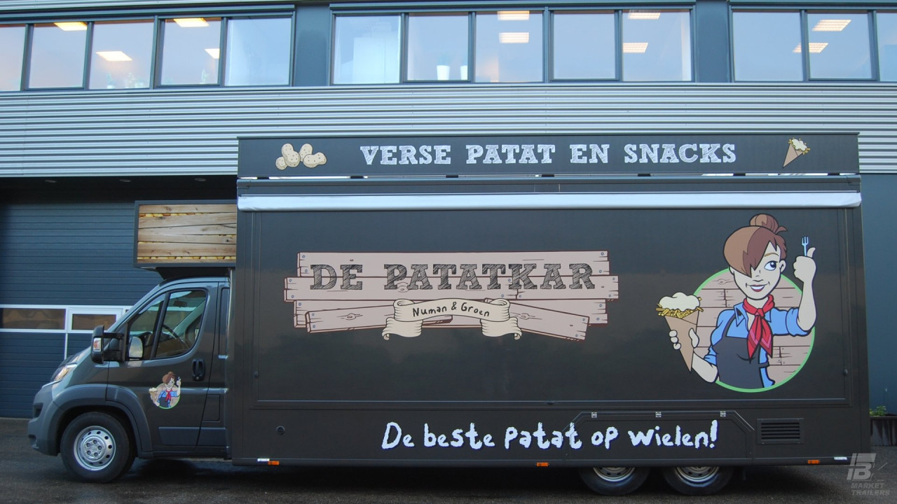 Zijaanzicht van een verkoopwagen voor patat met gesloten luifel