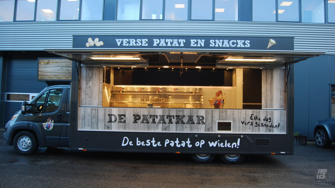 Zijaanzicht van een verkoopwagen voor patat met geopende luifel