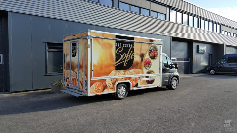 Zijaanzicht van een verkoopwagen voor gebak met gesloten luifel