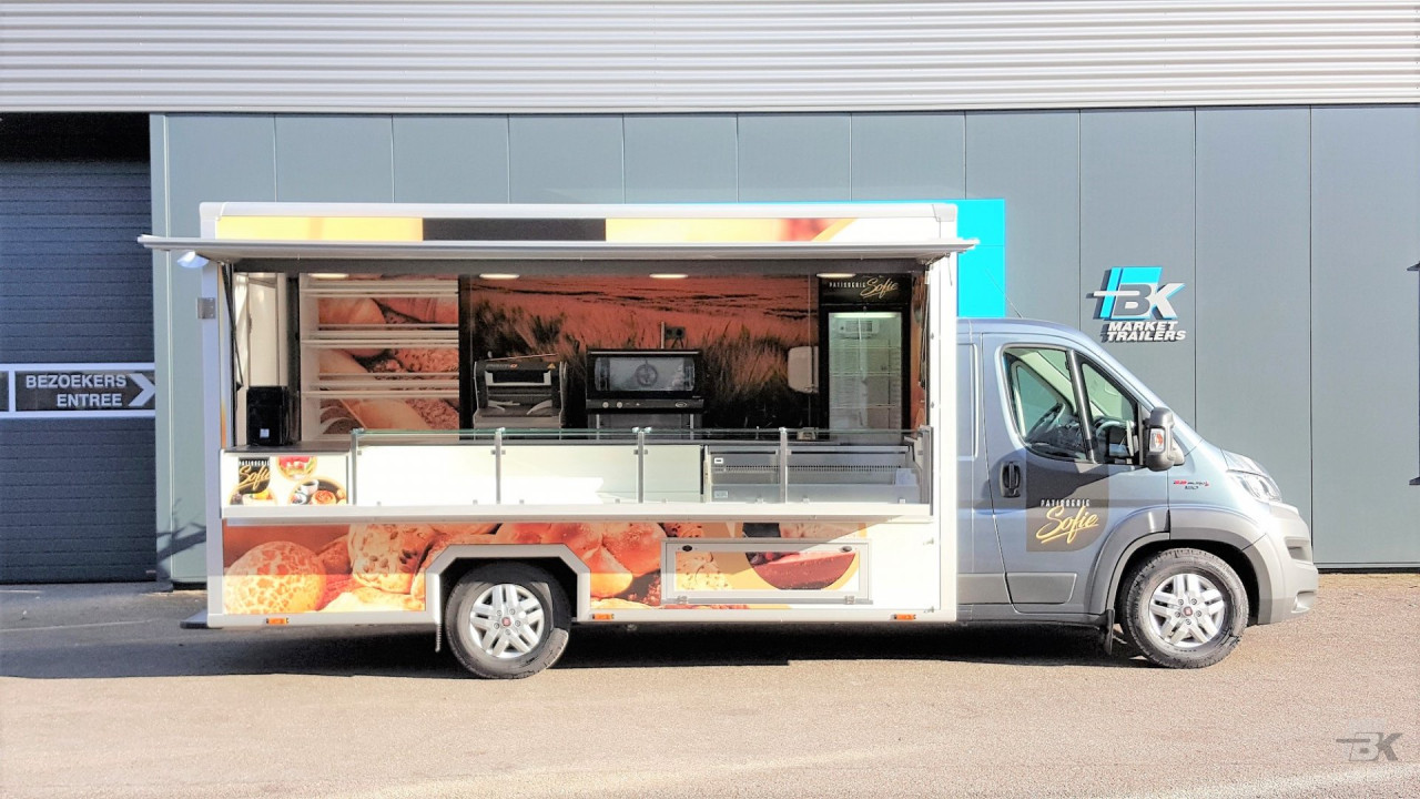 Zijaanzicht van een verkoopwagen voor gebak met geopende luifel