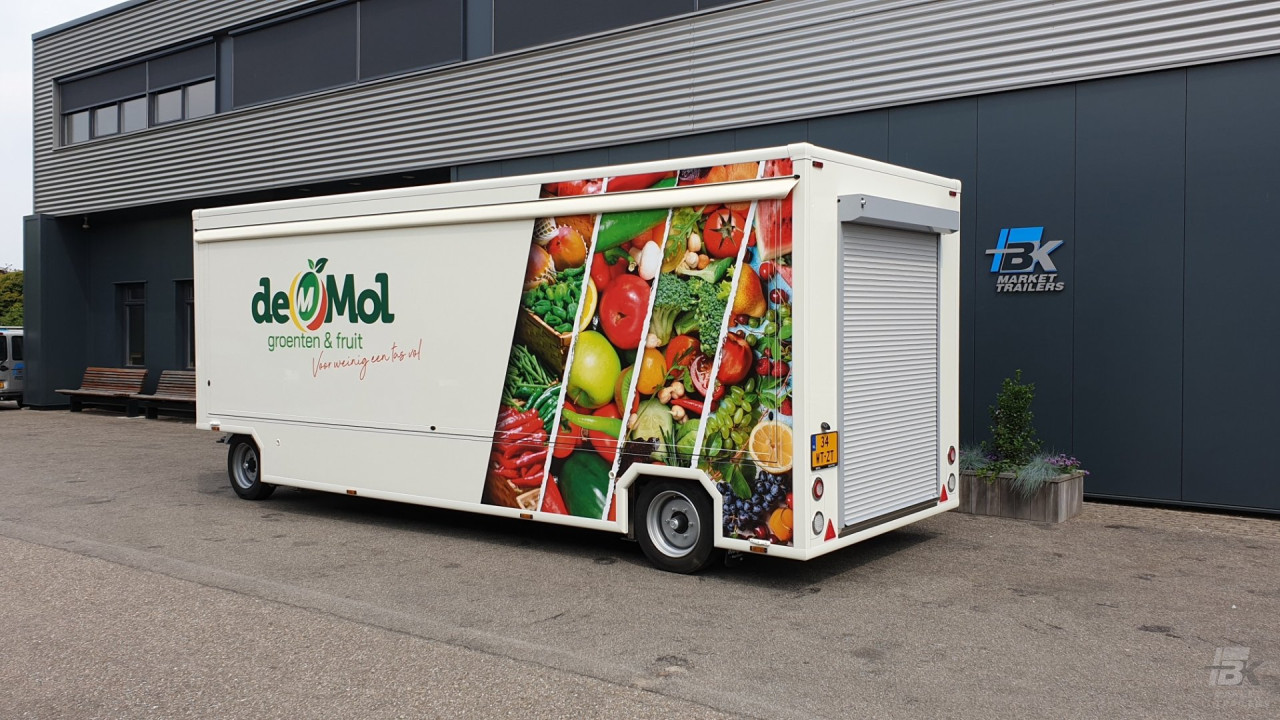 Zijaanzicht van een aanhangwagen voor groente en fruit met gesloten luifel