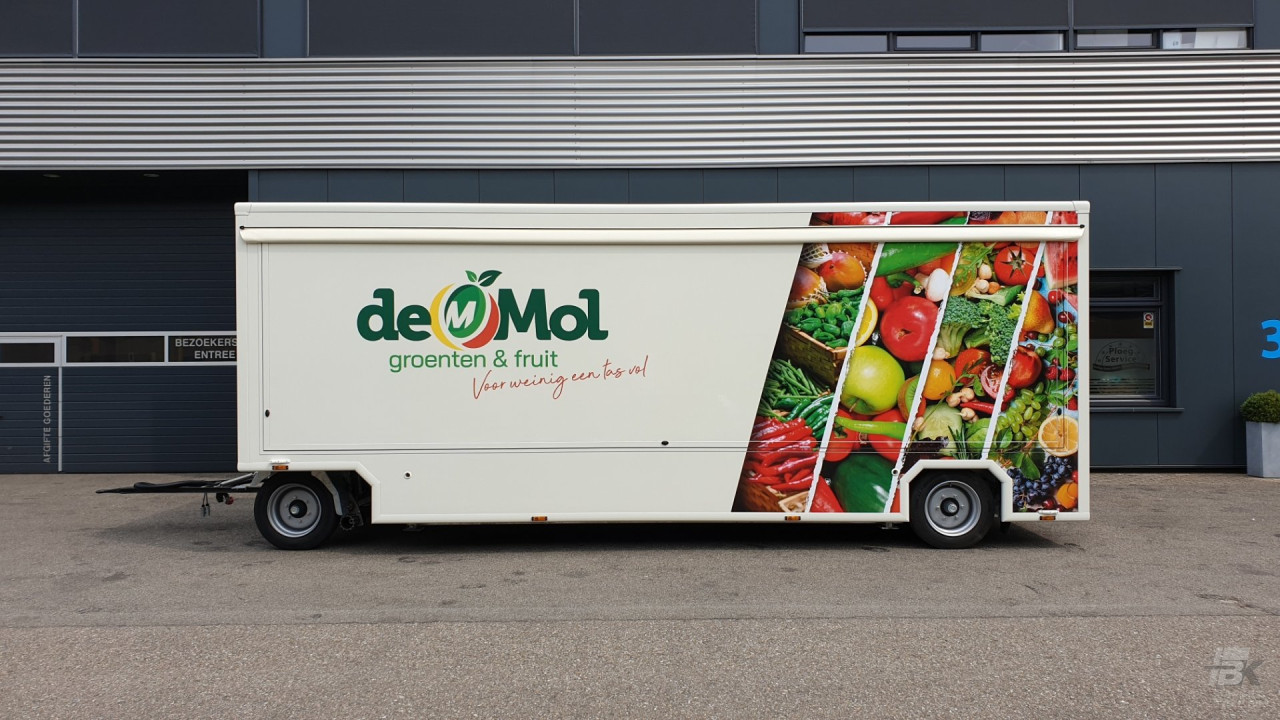 Zijaanzicht van een aanhangwagen voor groente en fruit met gesloten luifel