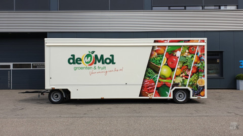 Zijaanzicht van een aanhangwagen voor groente en fruit met gesloten luifel