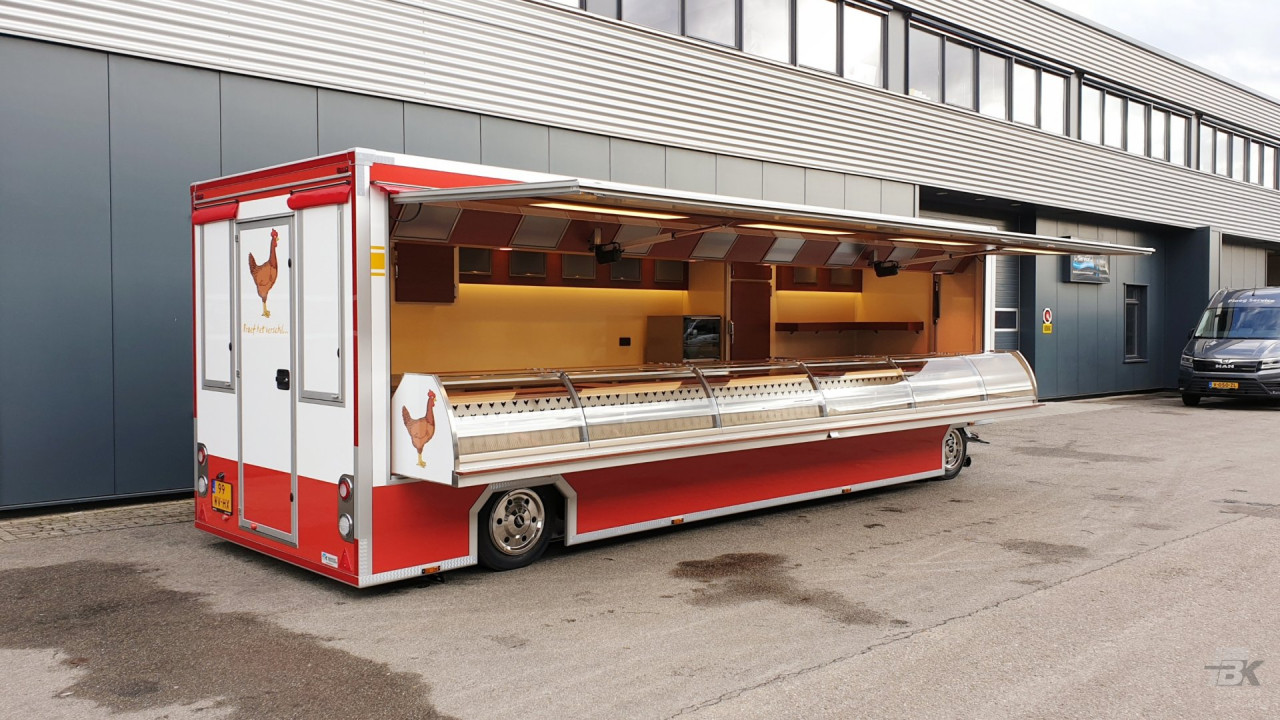 Zijaanzicht van een aanhangwagen voor kip met geopende luifel