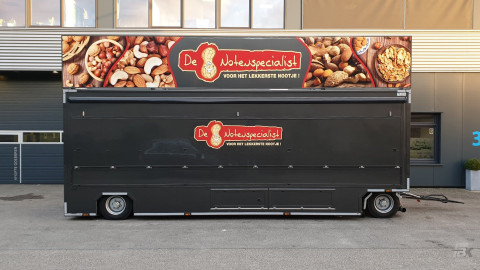 Zijaanzicht van een verkoopwagen voor noten met gesloten luifel
