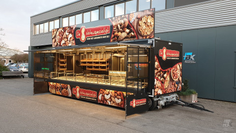 Zijaanzicht van een verkoopwagen voor noten met geopende luifel