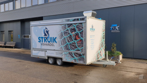 Zijaanzicht van een aanhangwagen voor vis met gesloten luifel