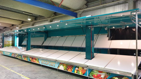 Zijaanzicht van een uitschuifbare aanhangwagen voor groente en fruit met geopende luifel