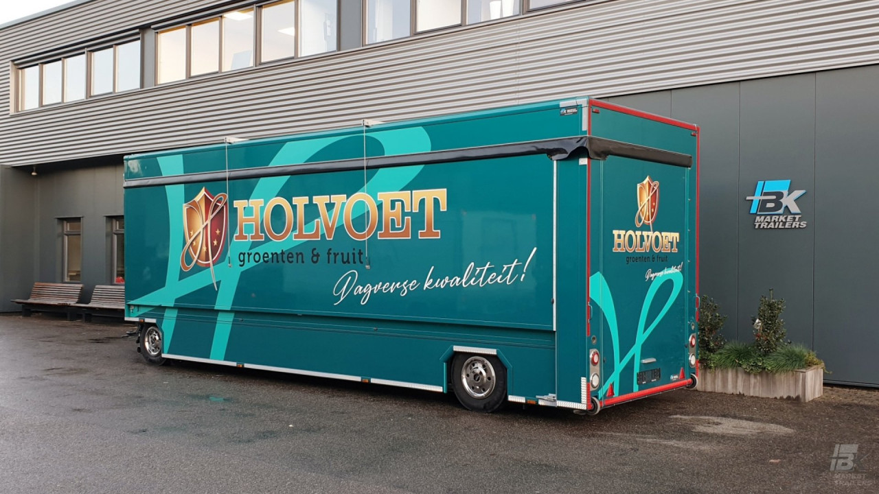 Zijaanzicht van een uitschuifbare aanhangwagen voor groente en fruit met gesloten luifel
