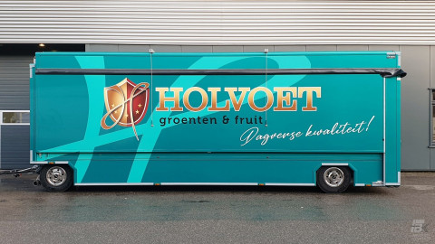 Zijaanzicht van een uitschuifbare aanhangwagen voor groente en fruit met gesloten luifel