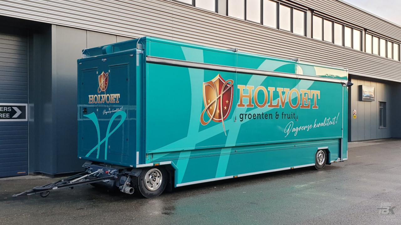 Zijaanzicht van een uitschuifbare aanhangwagen voor groente en fruit met gesloten luifel