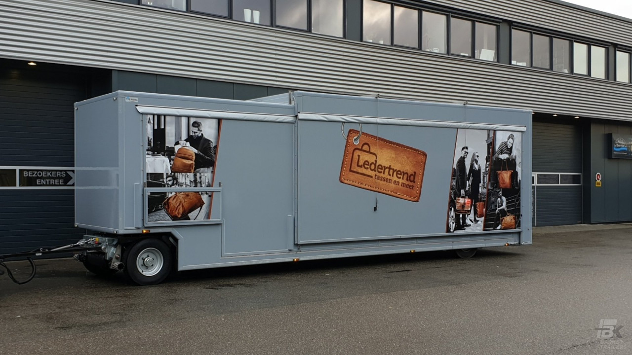 Zijaanzicht van een aanhangwagen voor lederwaren met gesloten luifel