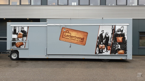 Zijaanzicht van een aanhangwagen voor lederwaren met gesloten luifel