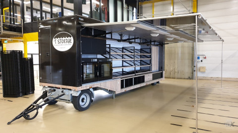 Zijaanzicht van een smalle aanhangwagen voor brood en banket met geopende luifel