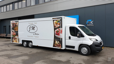 Zijaanzicht van een verkoopwagen voor kaas met gesloten luifel