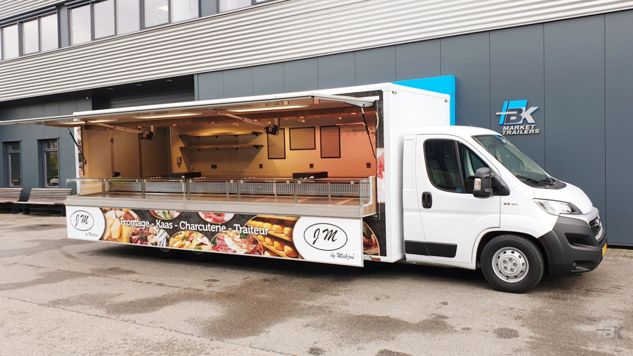 Zijaanzicht van een verkoopwagen voor kaas met geopende luifel