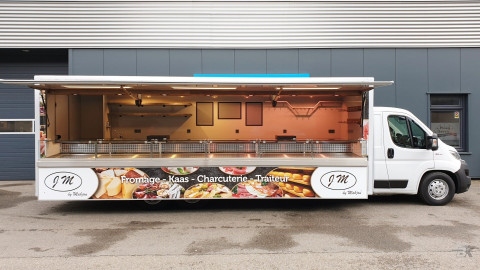 Zijaanzicht van een verkoopwagen voor kaas met geopende luifel