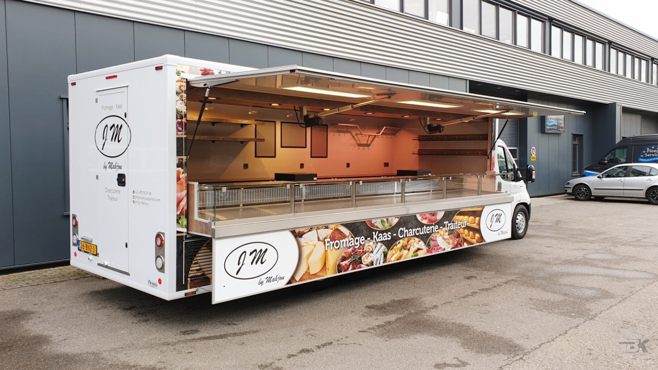 Zijaanzicht van een verkoopwagen voor kaas met geopende luifel