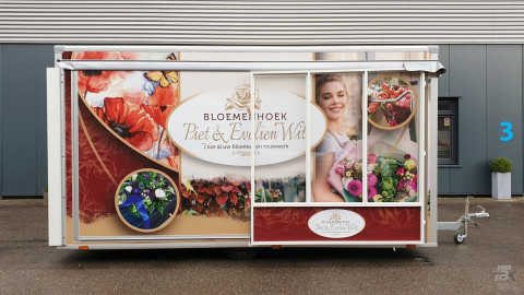 Zijaanzicht van een verkoopwagen voor bloemen met gesloten luifel