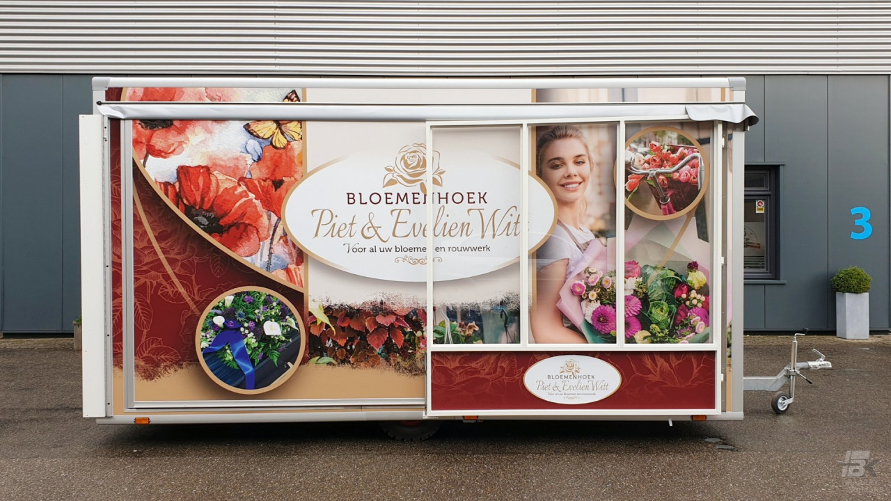 Zijaanzicht van een verkoopwagen voor bloemen met gesloten luifel