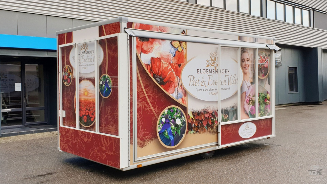 Zijaanzicht van een verkoopwagen voor bloemen met gesloten luifel