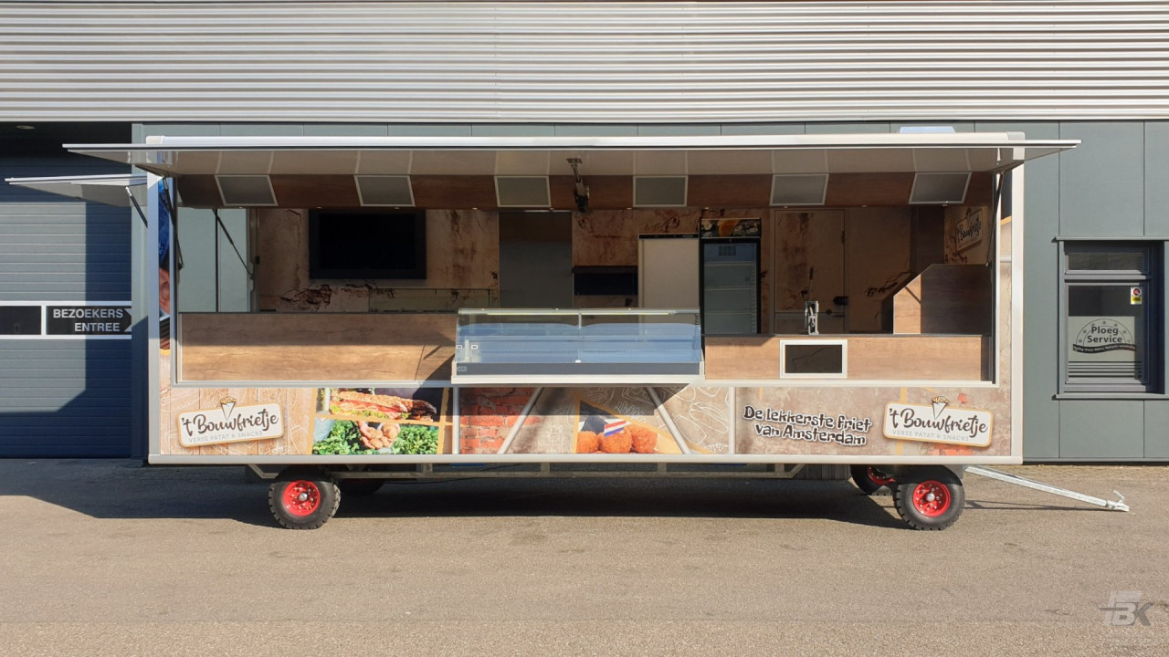 Zijaanzicht van een aanhangwagen voor patat en snacks met geopende luifel