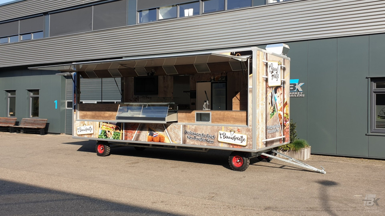Zijaanzicht van een aanhangwagen voor patat en snacks met geopende luifel