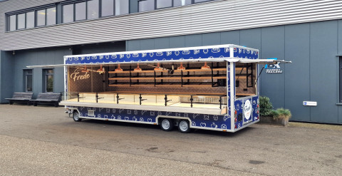 Zijaanzicht van een aanhangwagen voor brood en banket met geopende luifel