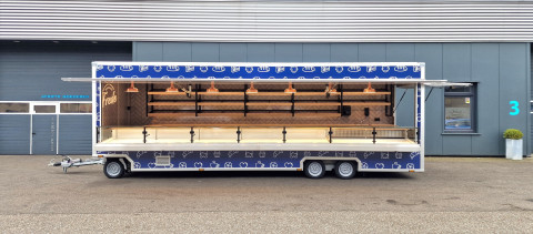 Zijaanzicht van een aanhangwagen voor brood en banket met geopende luifel