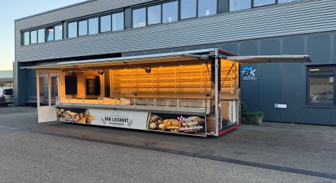 Zijaanzicht van een verkoopwagen voor brood met geopende luifel