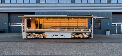 Zijaanzicht van een verkoopwagen voor brood met geopende luifel