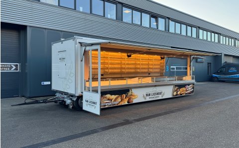 Zijaanzicht van een verkoopwagen voor brood met geopende luifel