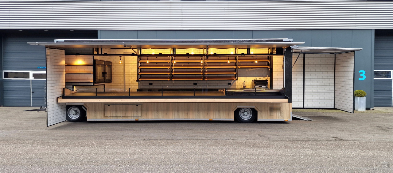 Zijaanzicht van een aanhangwagen voor brood en banket met geopende luifel en zijbord