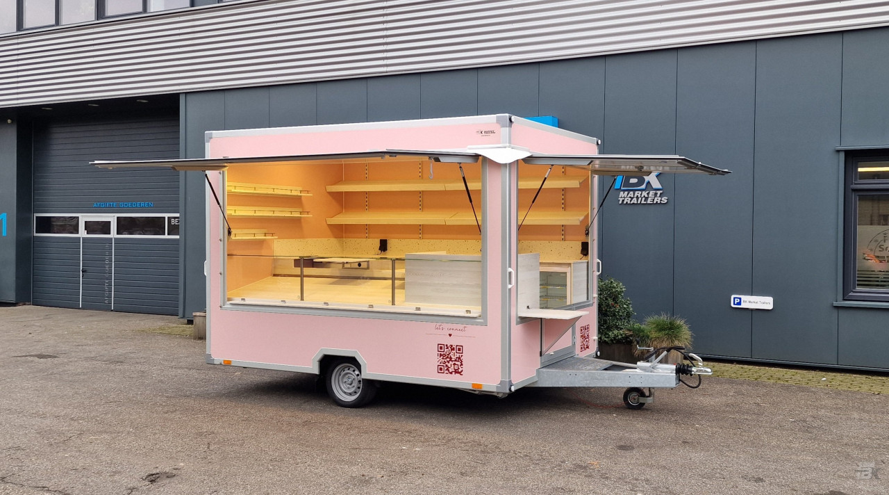 Zijaanzicht van een aanhangwagen voor koekjes, koffie en ijs met geopende luifel