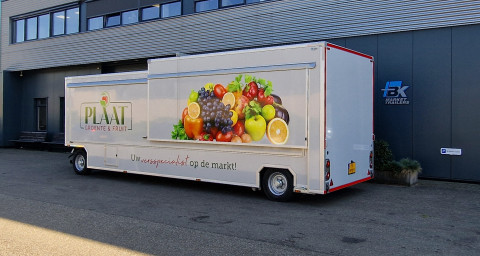 Zijaanzicht van een aanhangwagen voor groente en fruit met gesloten luifel