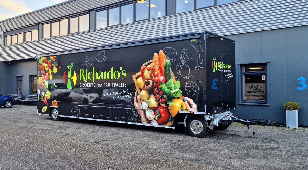 Zijaanzicht van een aanhangwagen voor groente en fruit met gesloten luifel