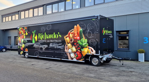 Zijaanzicht van een aanhangwagen voor groente en fruit met gesloten luifel