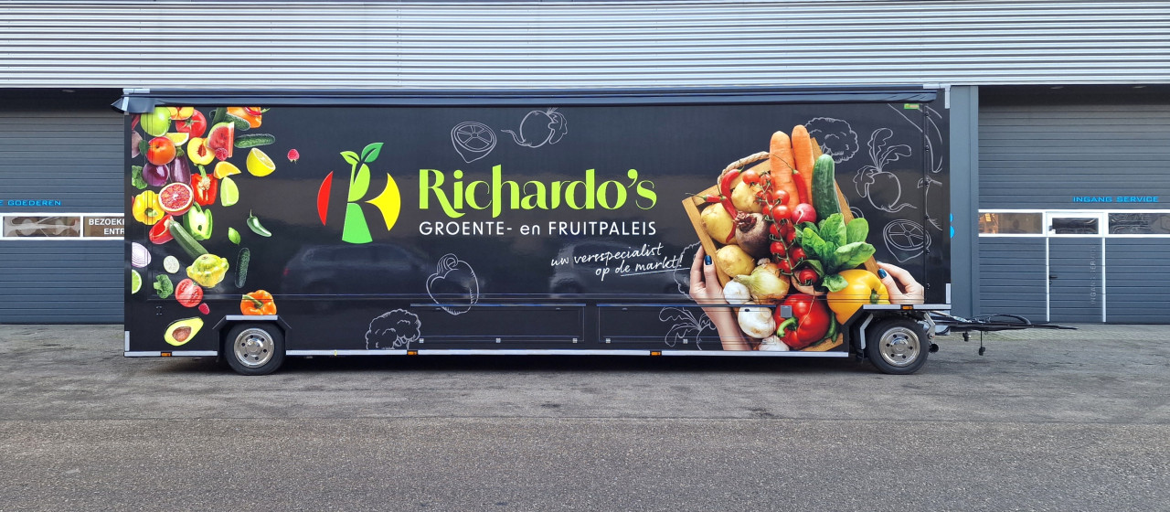 Zijaanzicht van een aanhangwagen voor groente en fruit met gesloten luifel
