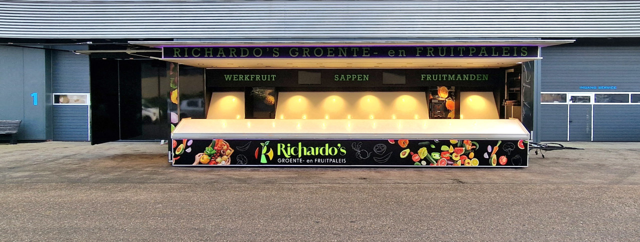 Zijaanzicht van een aanhangwagen voor groente en fruit met geopende luifel